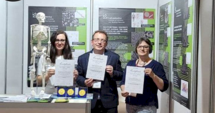 3 osoby trzymające dyplomy