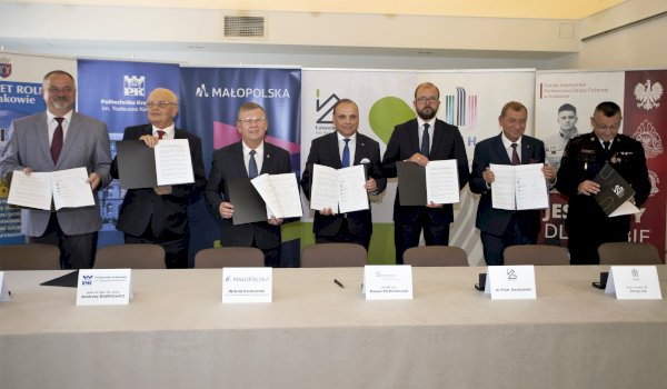 grupa mezczyzn trzymajaca dyplomy