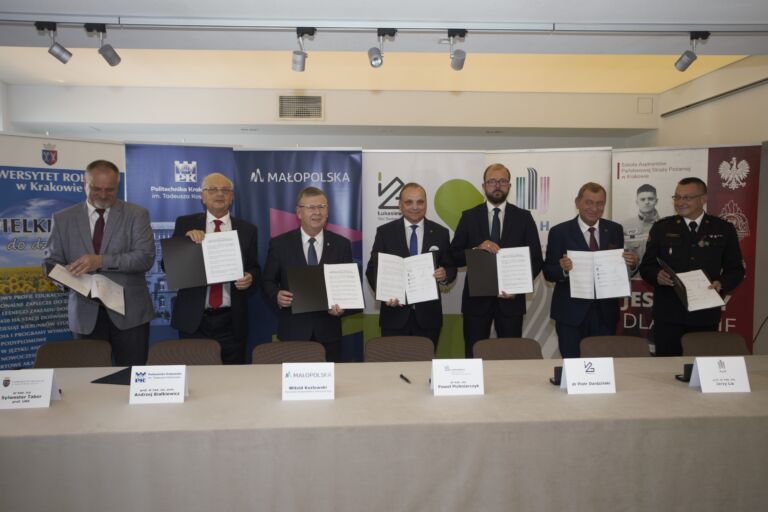 grupa mężczyzn trzymająca dokument